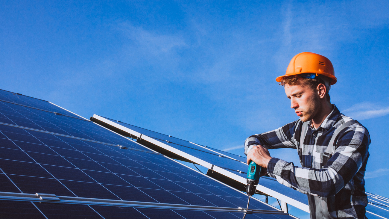Man worker in the firld by the solar panels