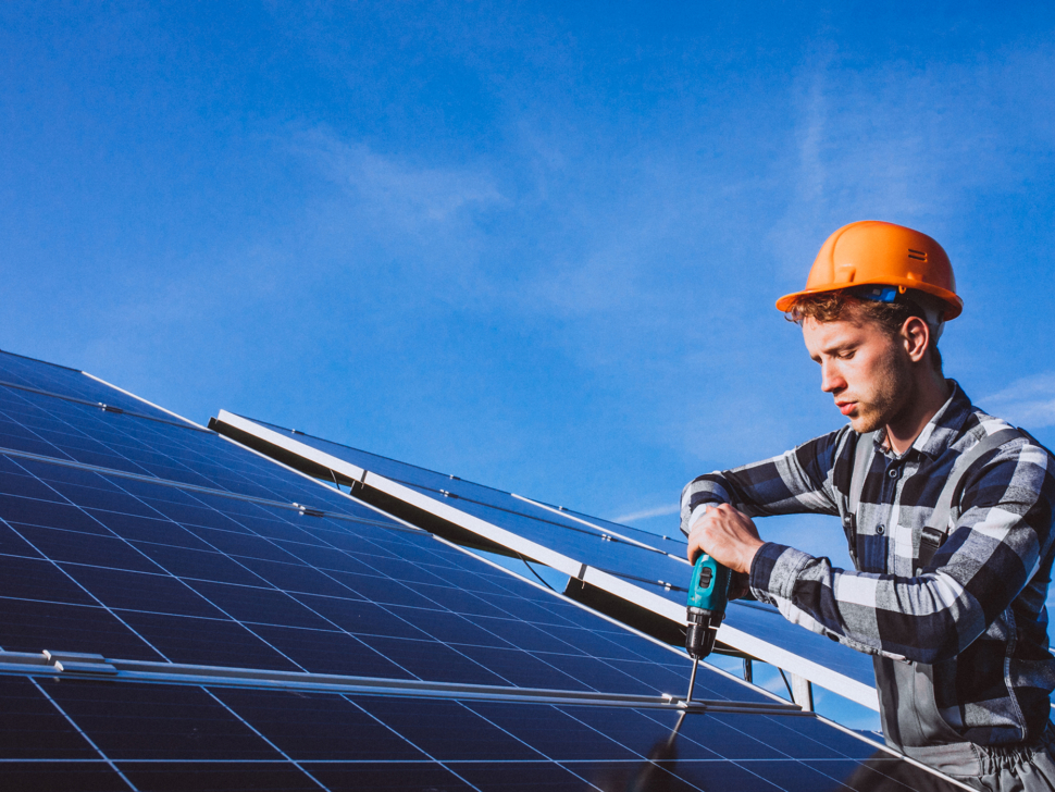 Man worker in the firld by the solar panels
